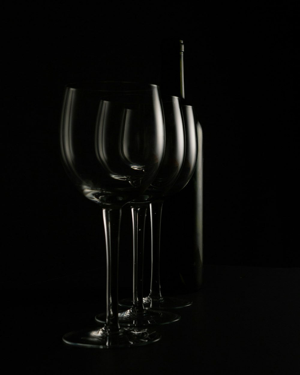 a group of wine glasses sitting next to a bottle