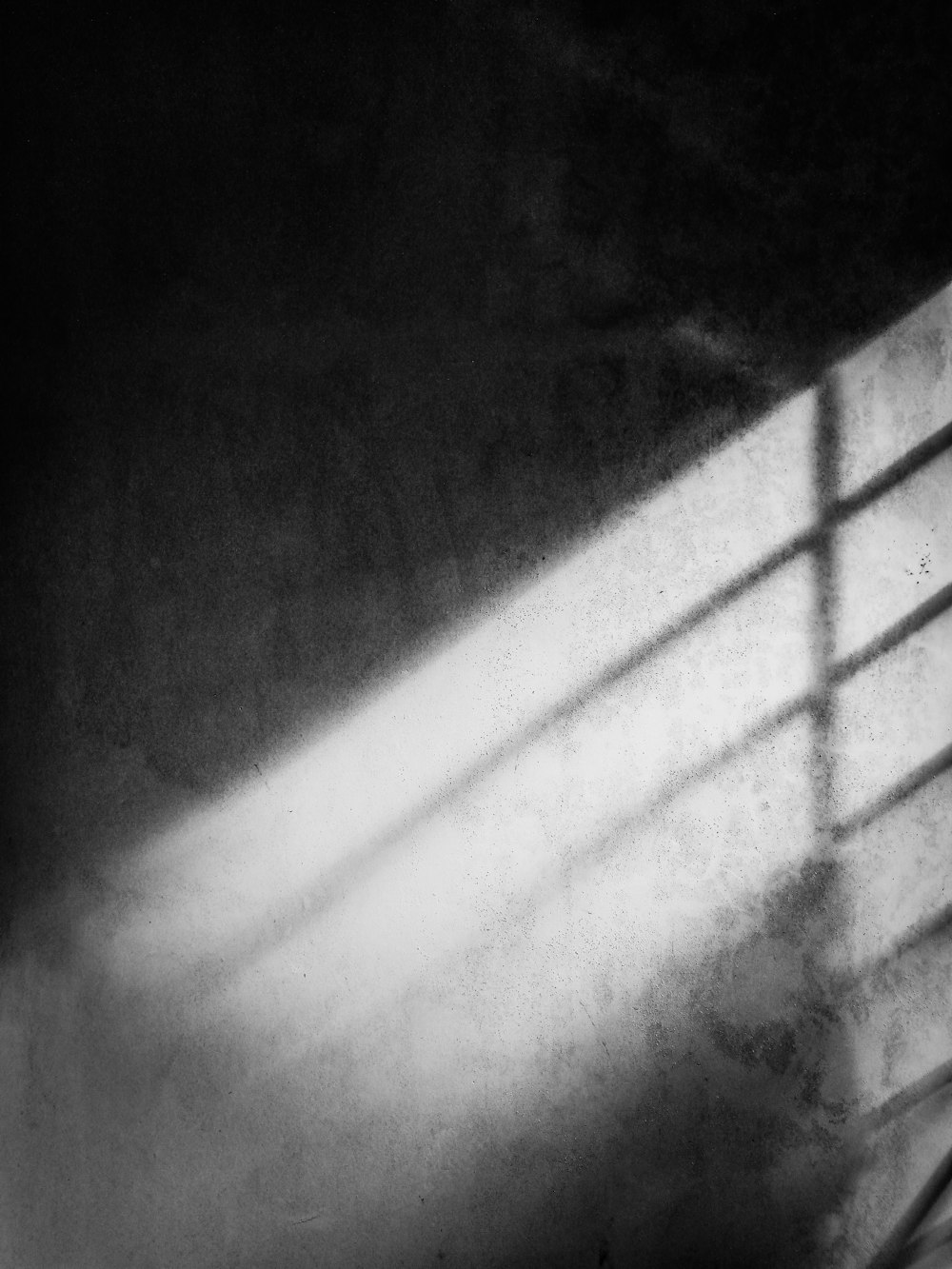ein Schwarz-Weiß-Foto einer Wand und eines Fensters