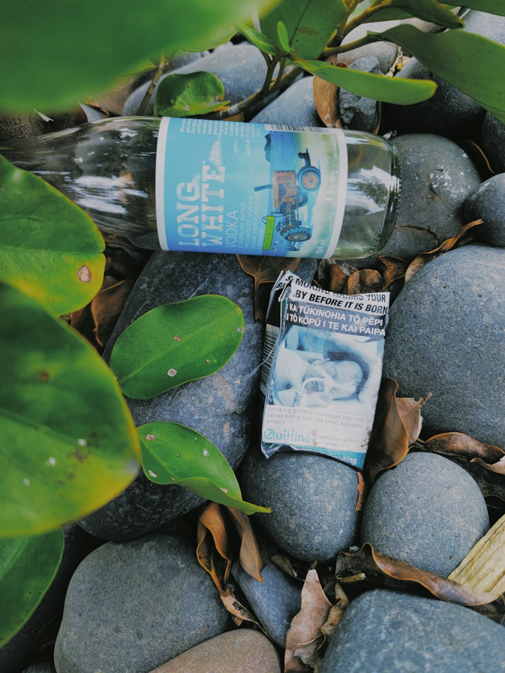 a bottle of water sitting on top of a pile of rocks