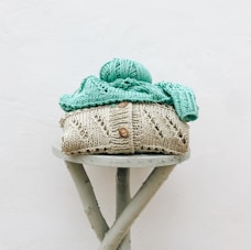 a knitted hat sitting on top of a wooden stool