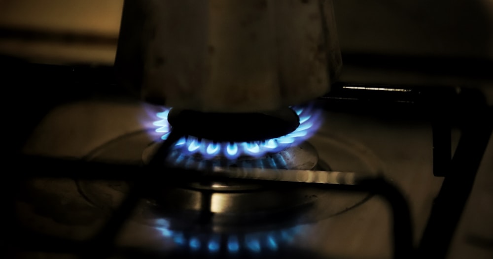 a gas stove with blue flames in a dark room