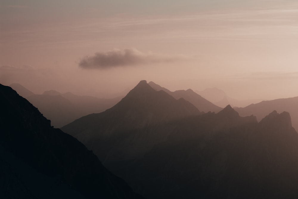 a view of a mountain range with a cloud in the sky