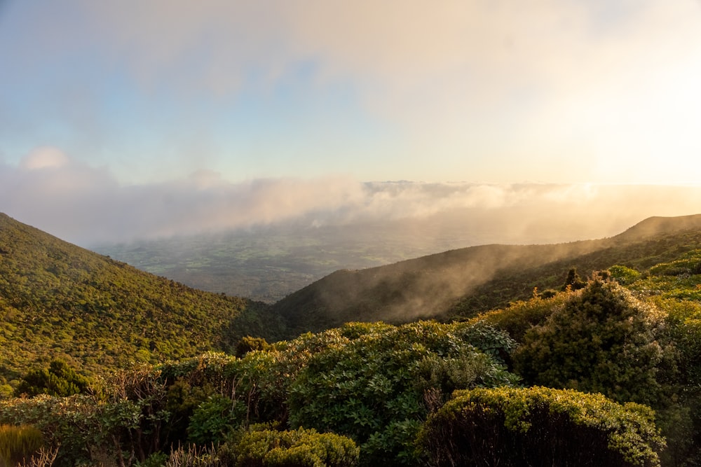 the sun shines through the clouds in the mountains