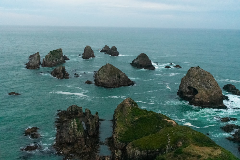 a group of rocks sitting on top of the ocean