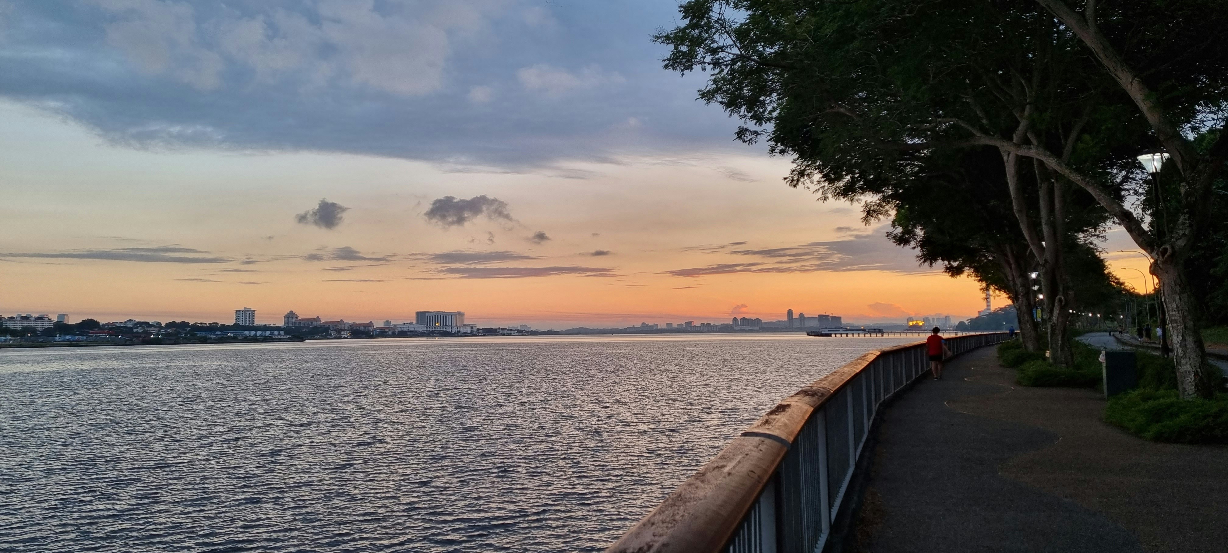 Runners jogging along city waterfront at sunset