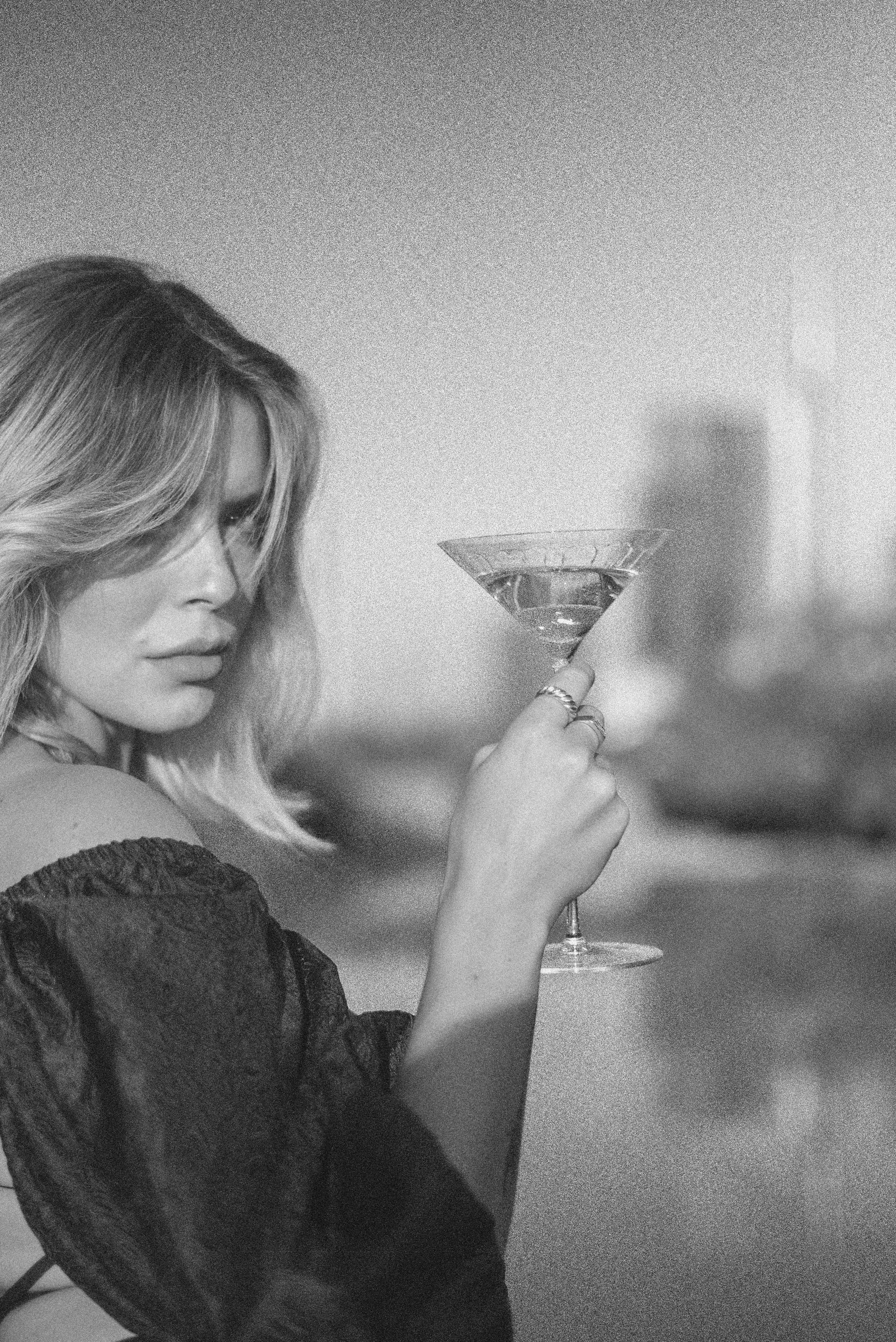 a woman holding a martini glass in her hand