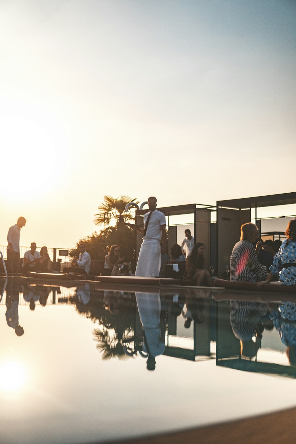 a group of people sitting next to a swimming pool