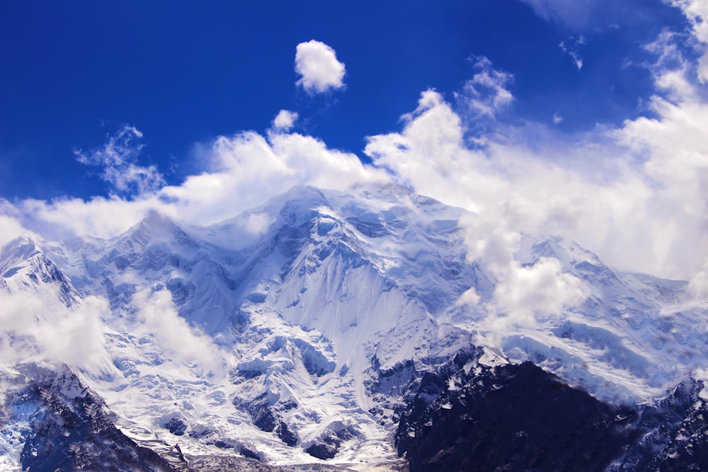 a snow covered mountain range under a partly cloudy sky