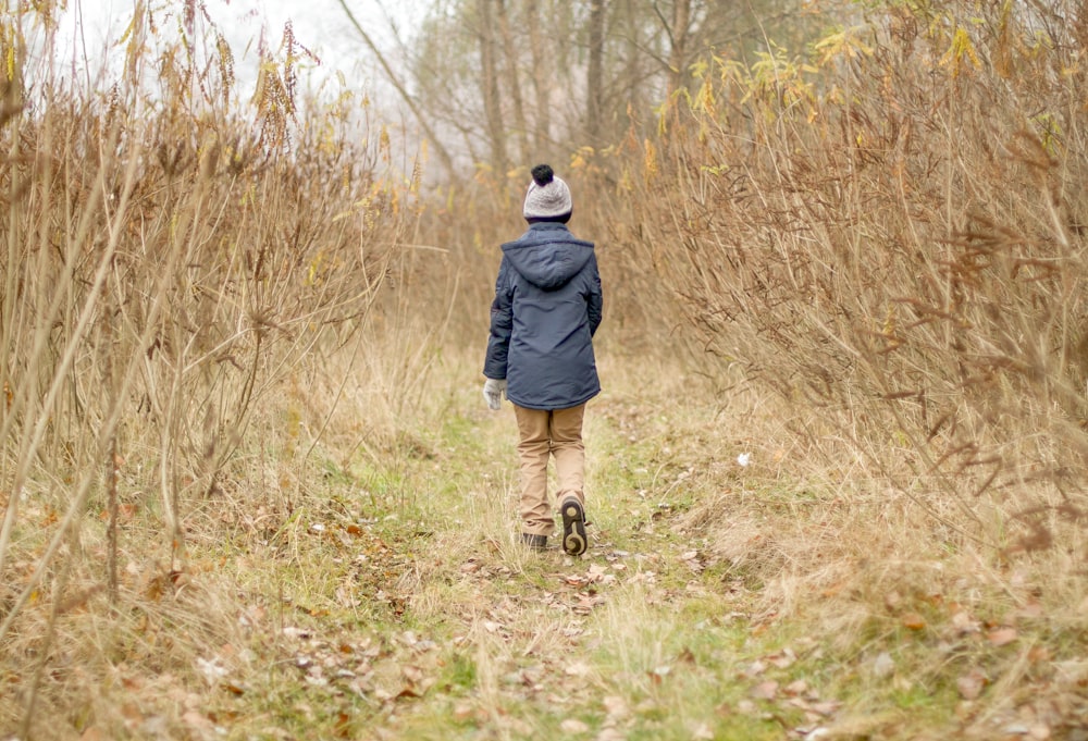 a person walking through a field of tall grass