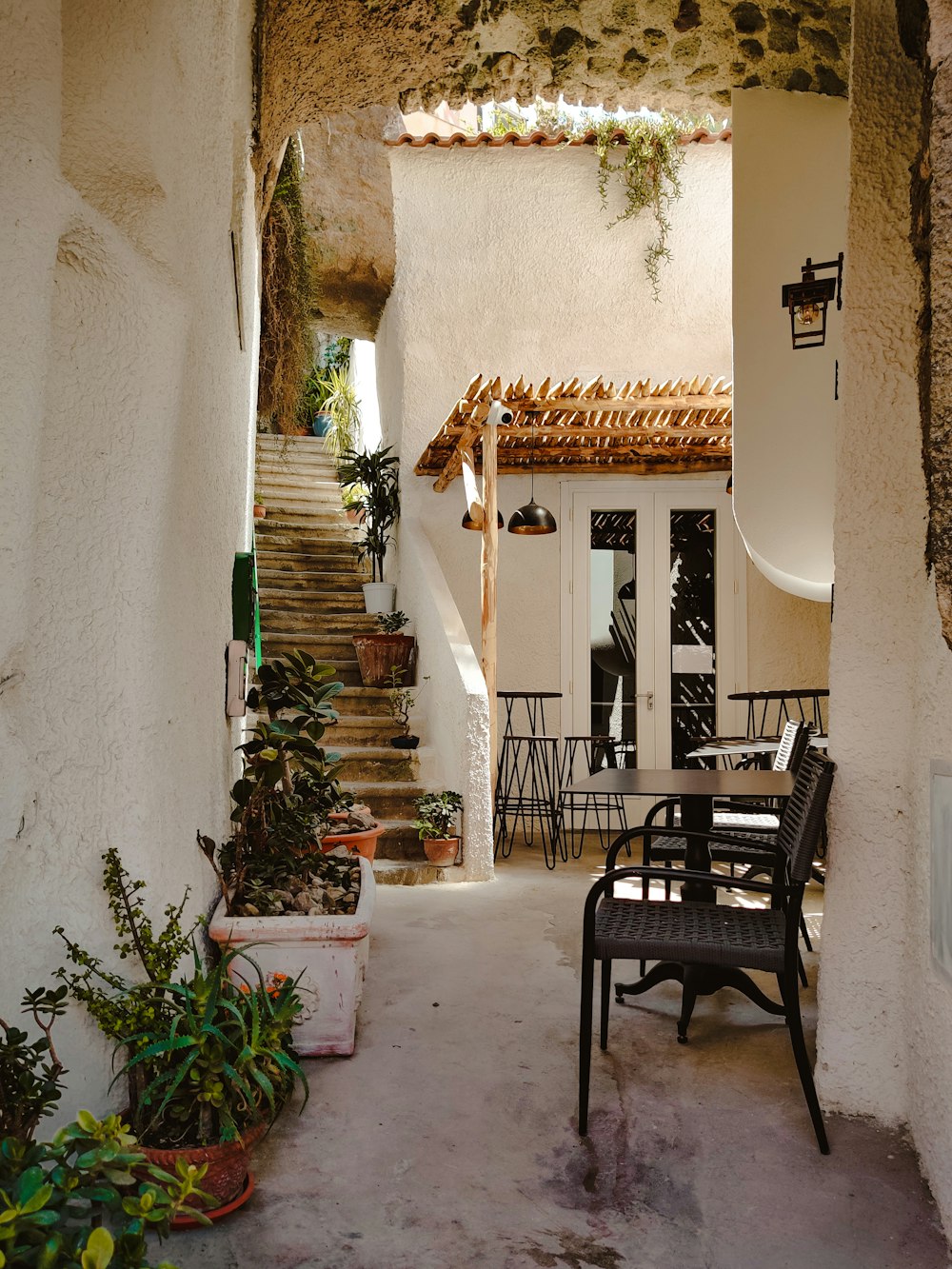 a patio with a table and chairs next to a set of stairs