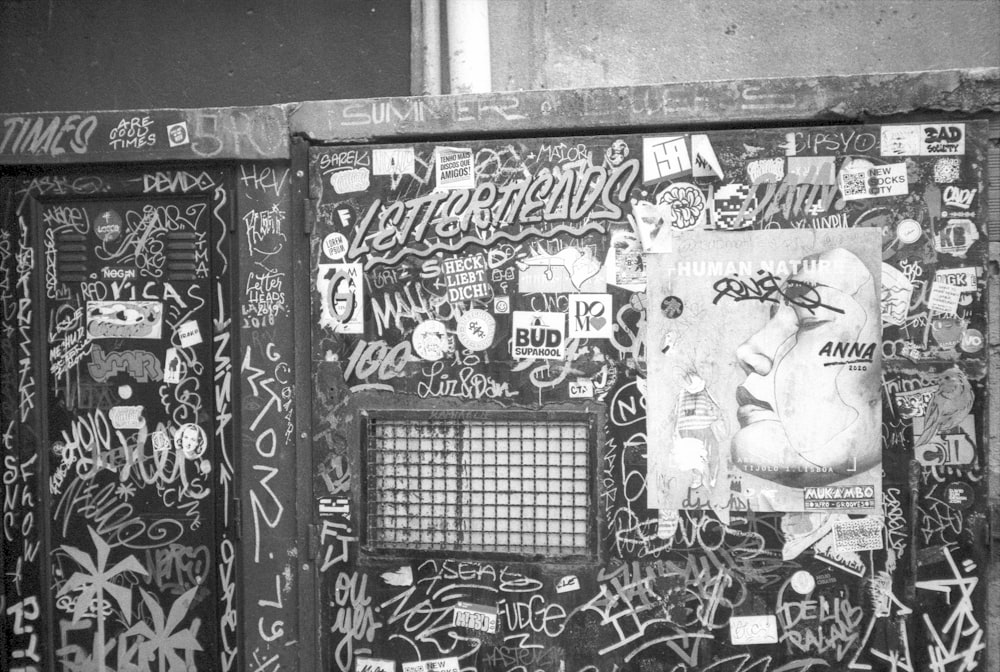 black and white photograph of a wall covered in graffiti