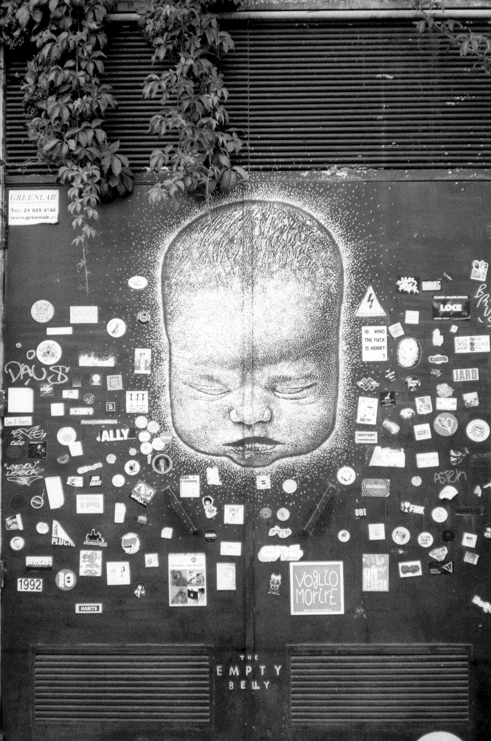 a black and white photo of a child's face on a wall