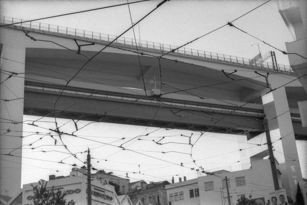 a black and white photo of a bridge over a street