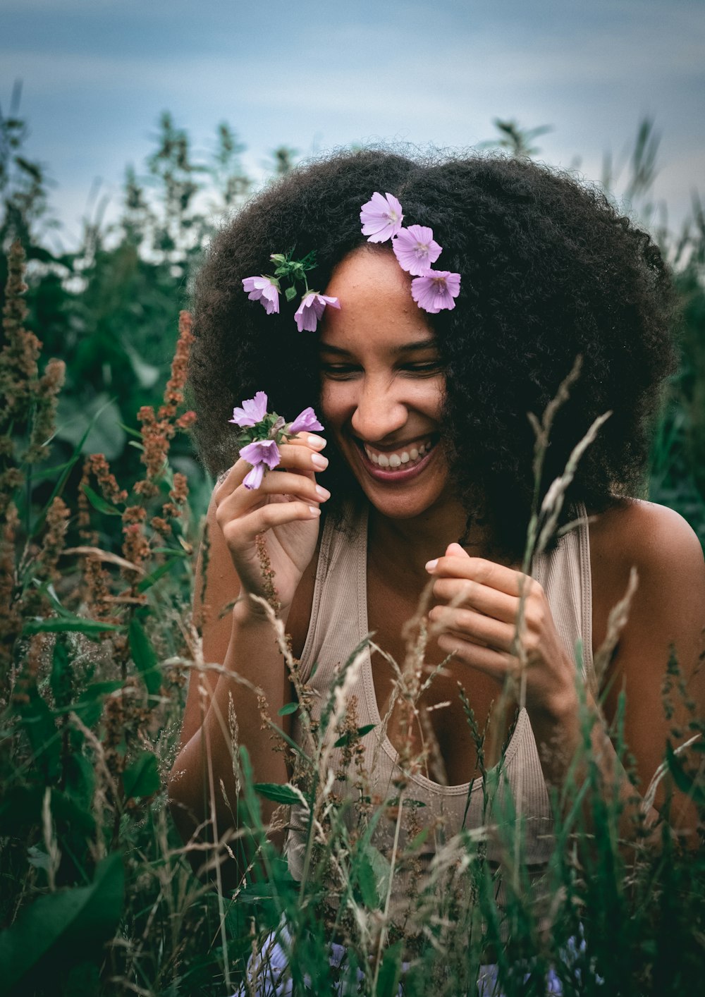 a woman is smiling and holding flowers in her hands
