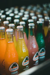 a row of bottles filled with different colored drinks