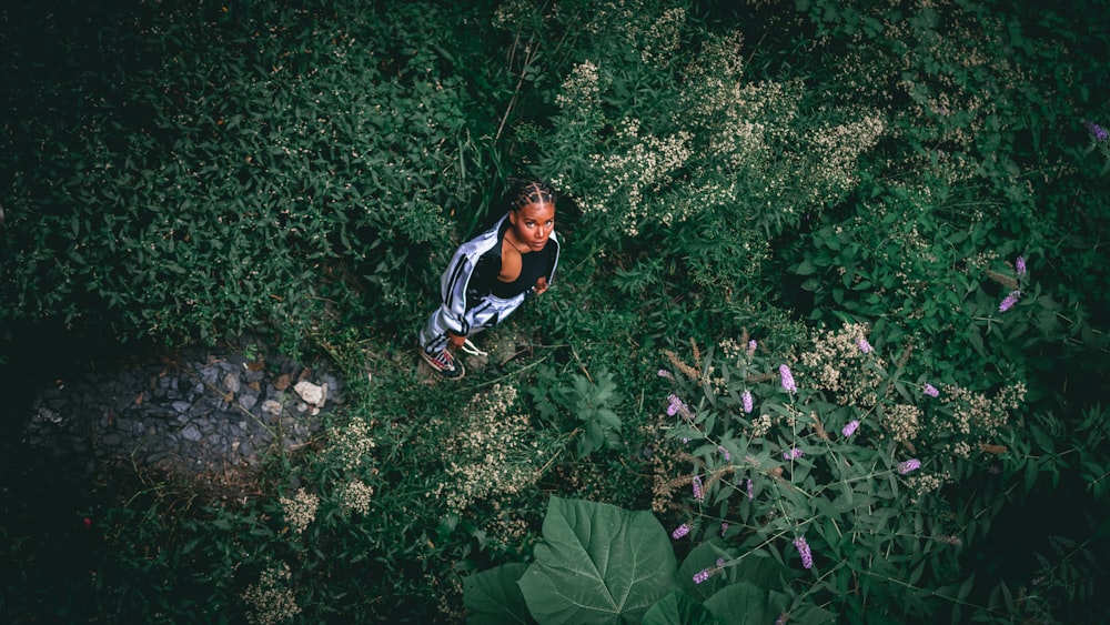 a woman walking through a lush green forest