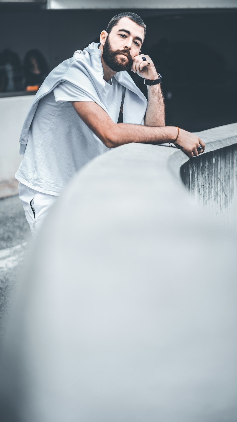 a man with a beard is leaning on a wall