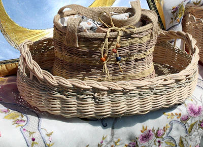 Artisan-crafted decorative basket filled with vibrant textiles on a rustic wooden floor.