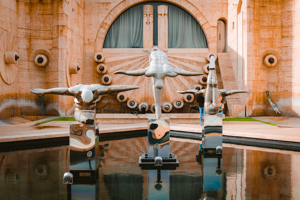 a group of sculptures sitting on top of a pool of water