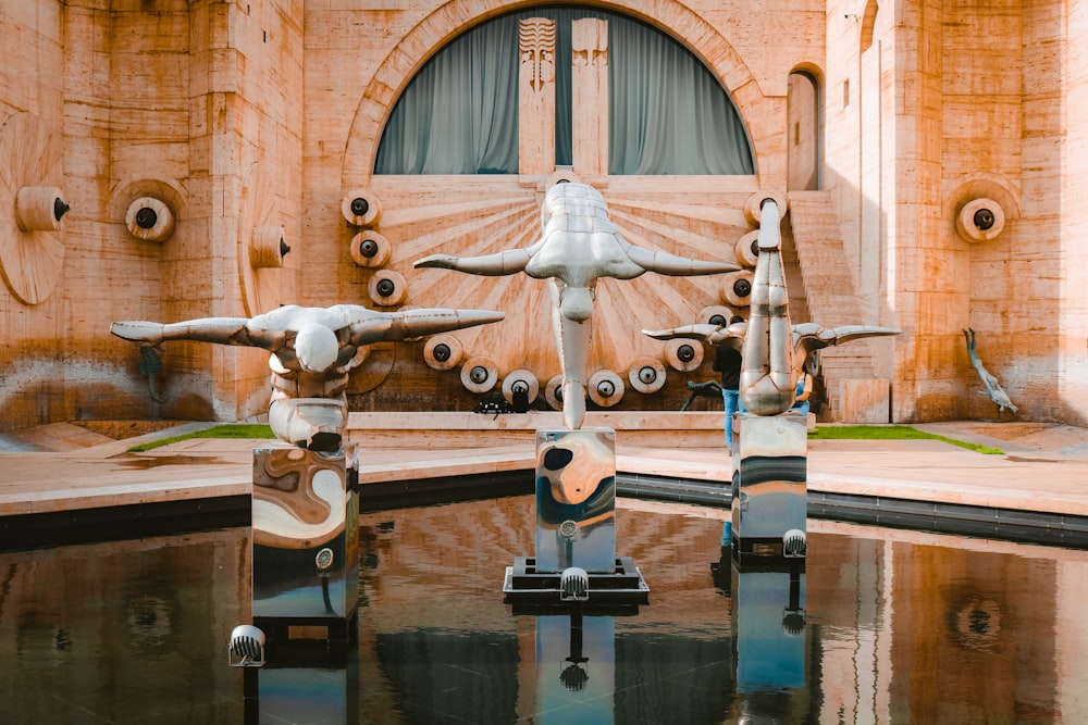 Un grupo de esculturas sentadas encima de un charco de agua