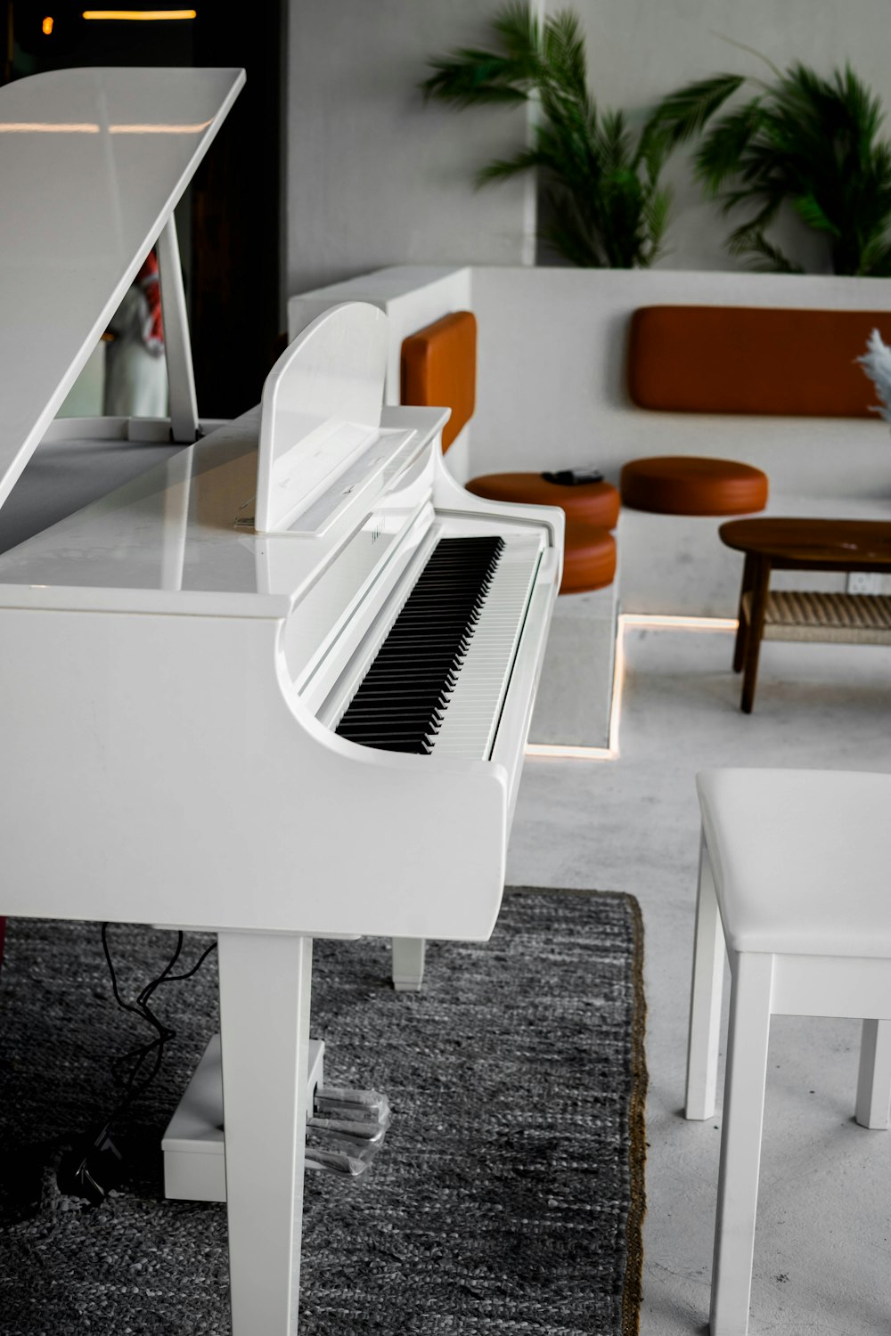 a white piano sitting on top of a rug