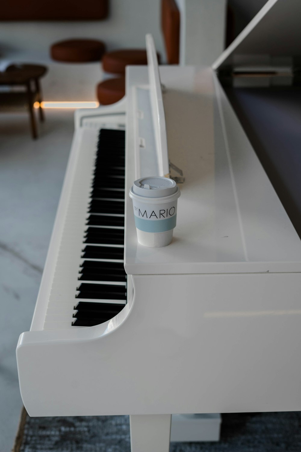 a white piano with a cup of coffee on top of it