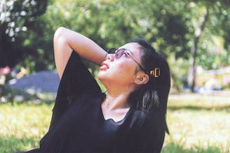 A relaxed person enjoying a sunny afternoon with verdavibe cannabis in hand, surrounded by greenery.