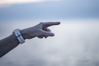 a hand pointing at something in the sky