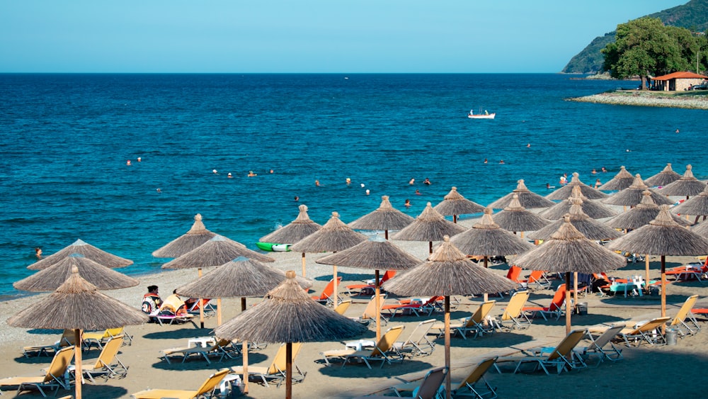 Ein Haufen Sonnenschirme, die an einem Strand sind