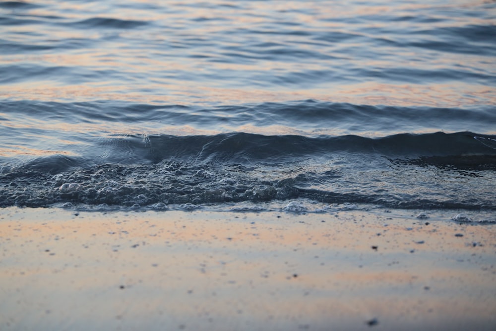 a close up of the water and sand of a beach