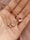 a woman's hand holding four different necklaces