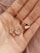 a woman's hand holding four different necklaces