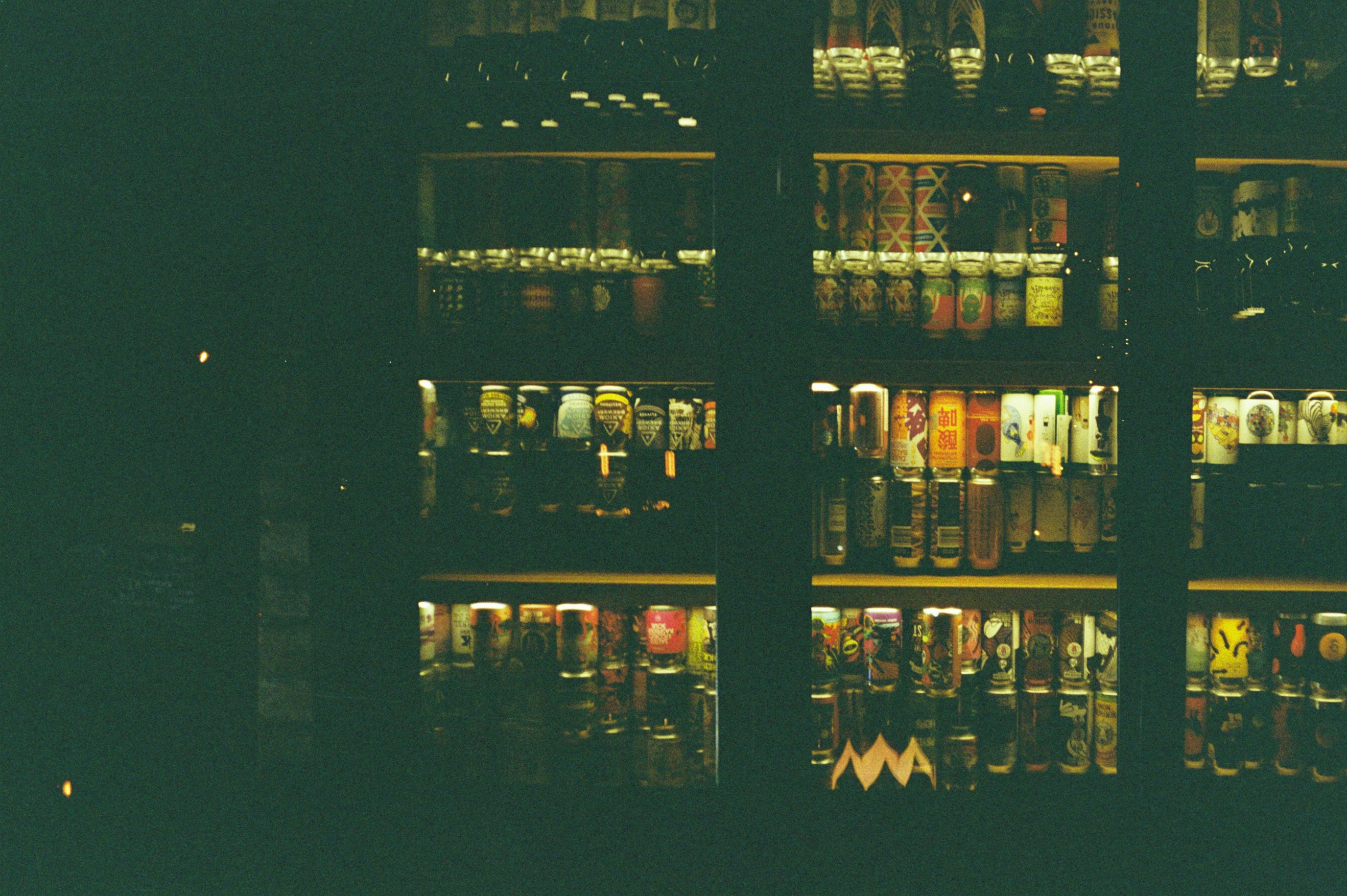 a shelf full of beer bottles in a dark room