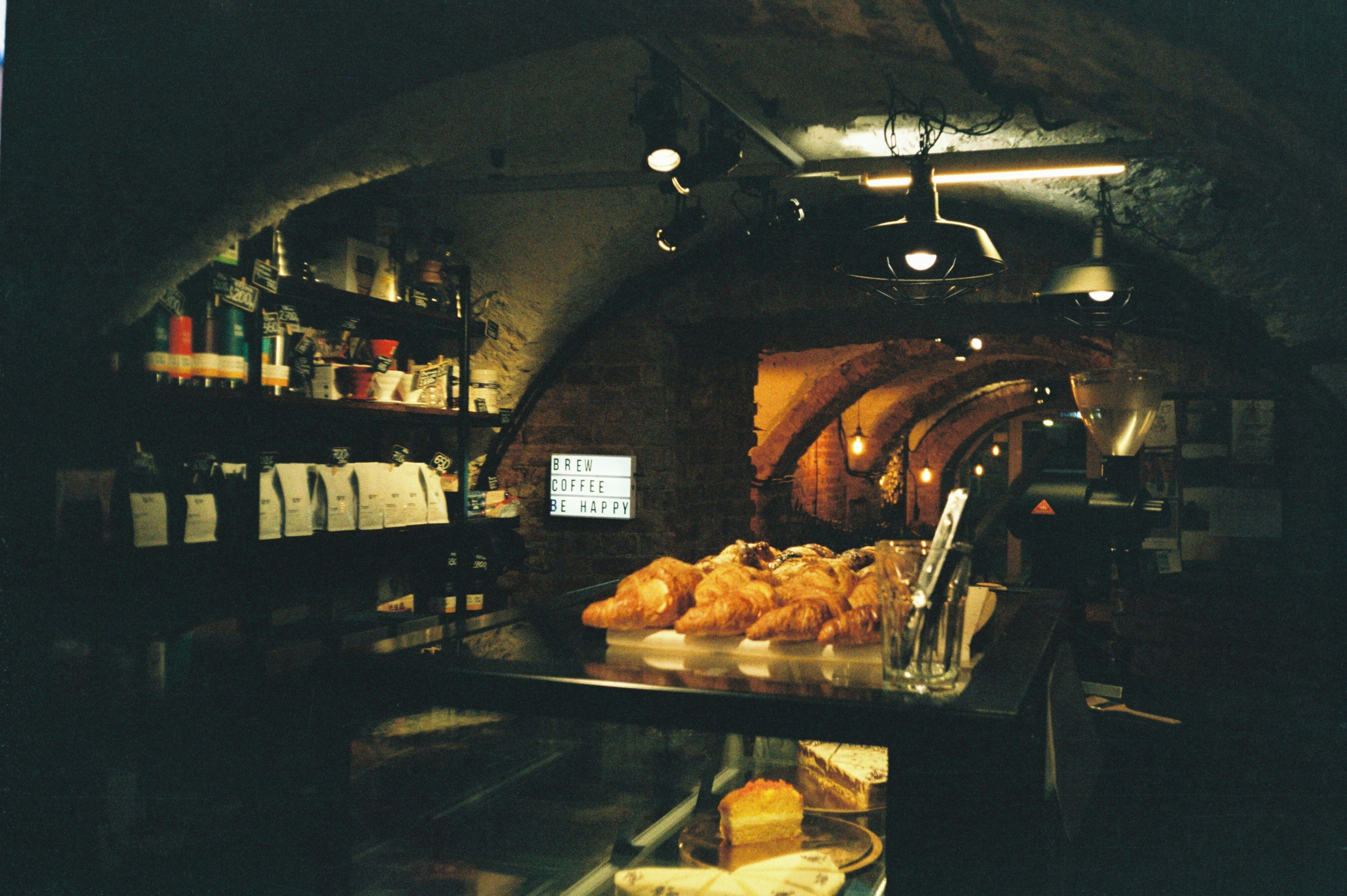 Assorted pastries and cake slices on dark marble, moody bakery atmosphere, deep shadows, dramatic low-key lighting