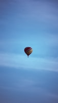 A colorful hot air balloon floating in a clear blue sky.