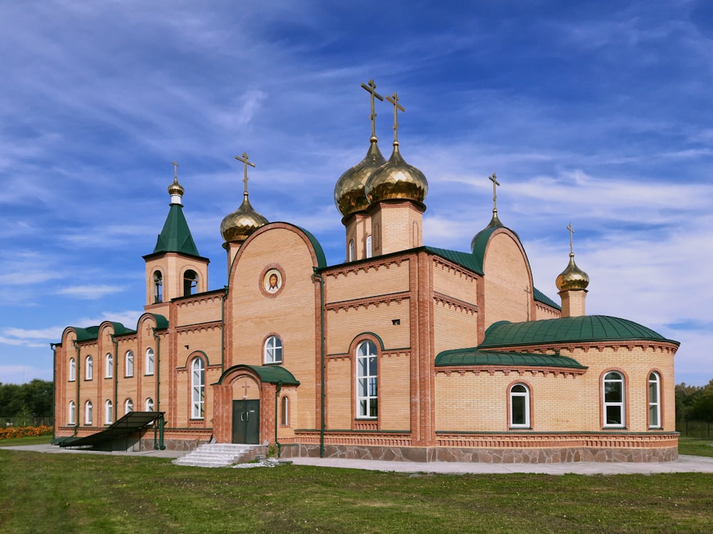 a church with a green roof and gold domes