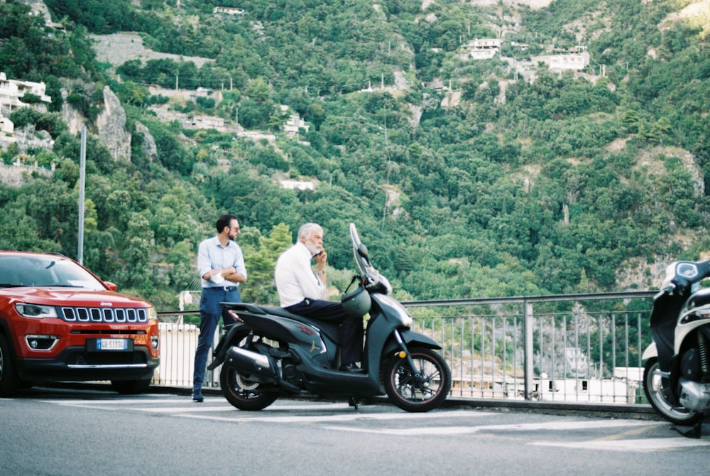 a couple of men standing next to a parked motorcycle