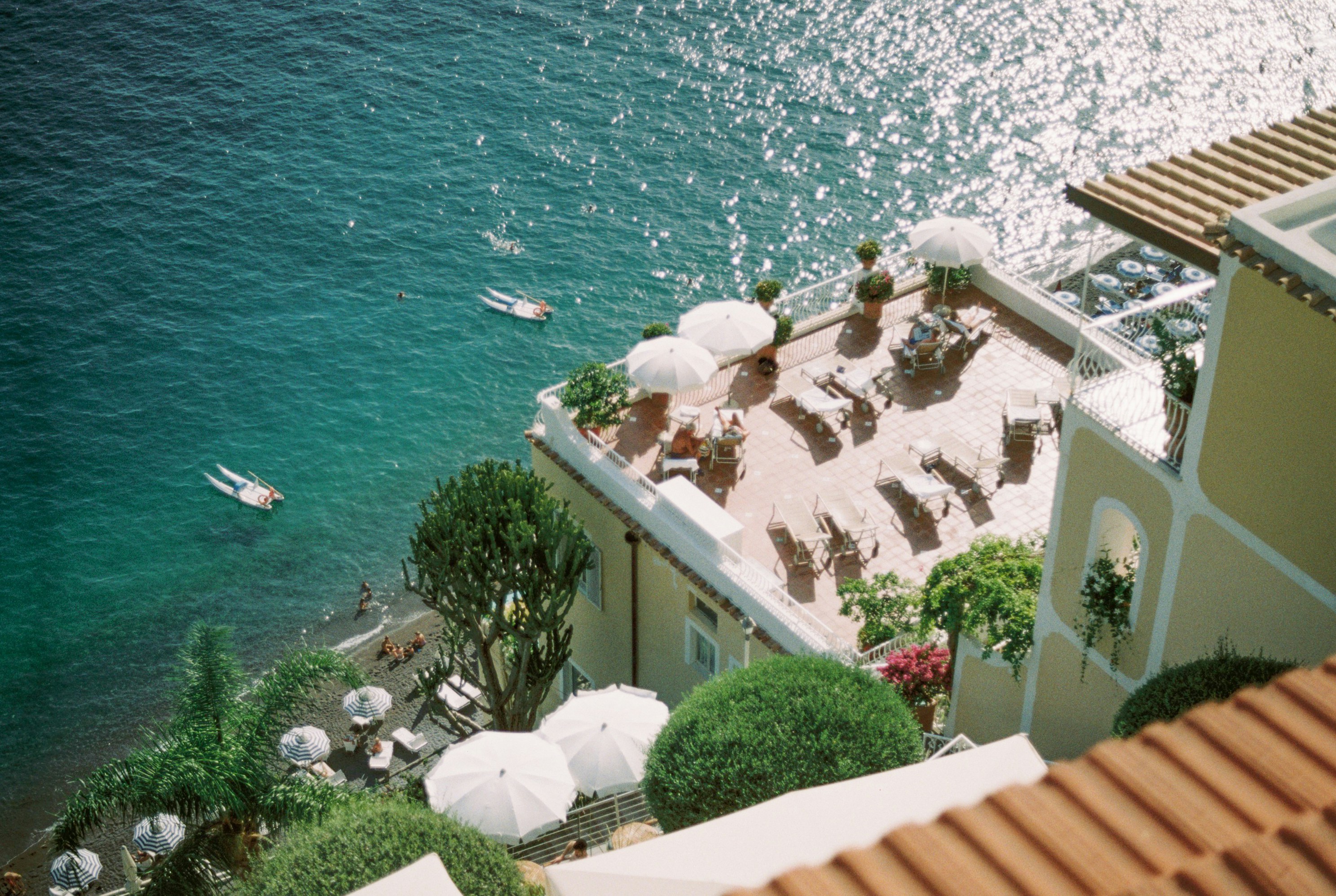 an aerial view of a beach with umbrellas and chairs