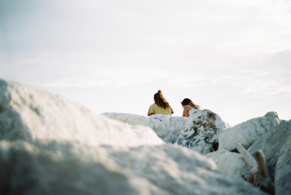 a couple of women sitting on top of rocks