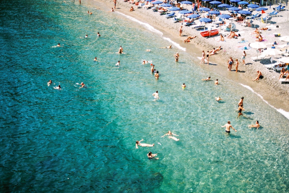 a group of people on a beach with umbrellas