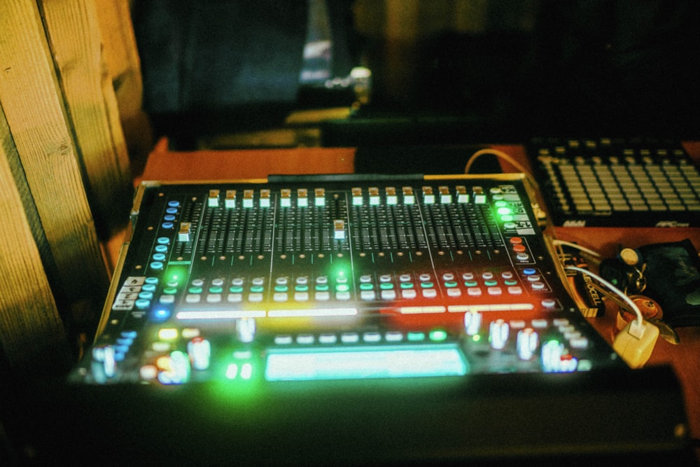 a sound mixing console sitting on top of a wooden table