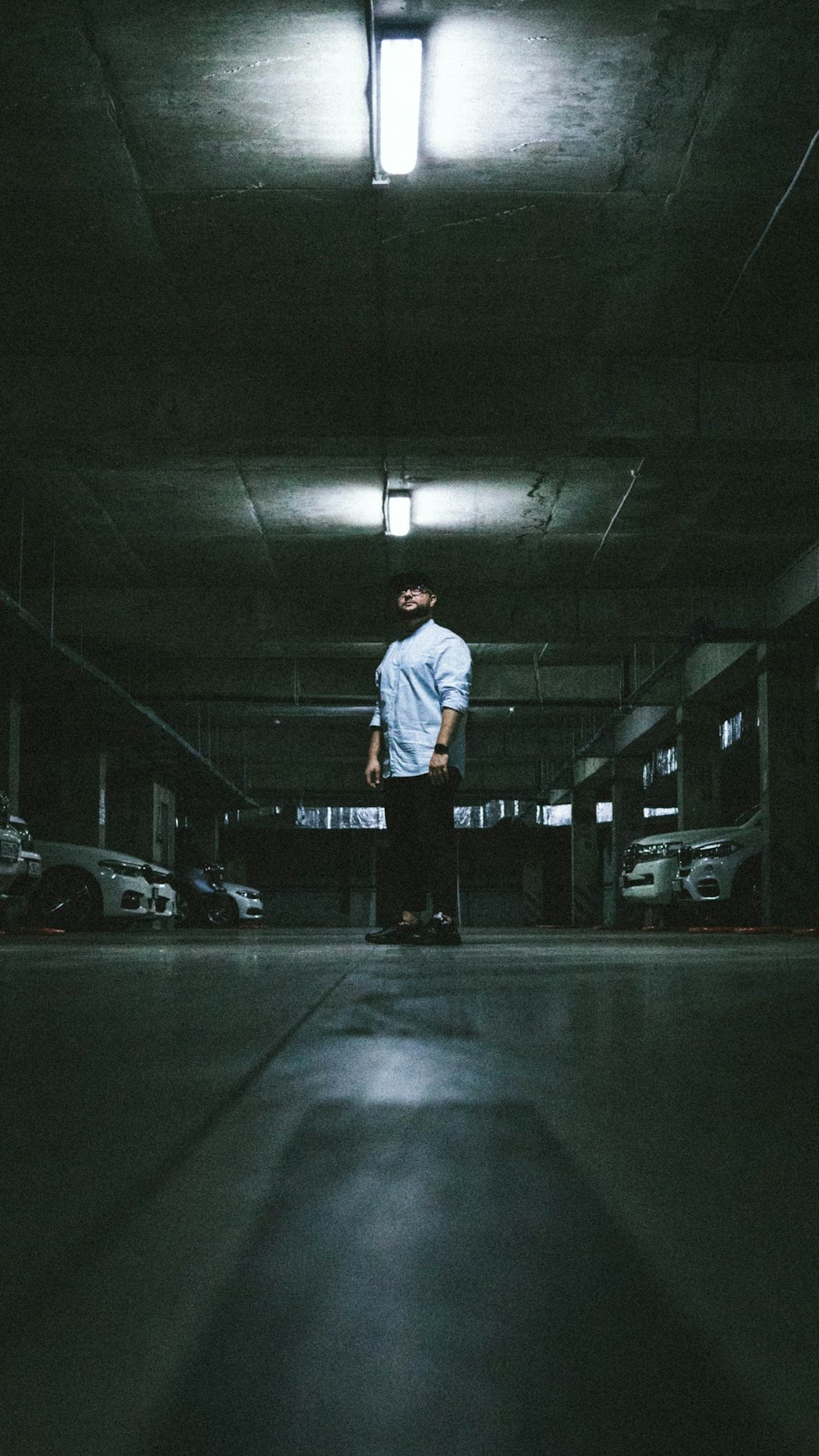 a man standing in a parking garage with a suitcase