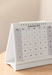 a desk calendar sitting on top of a wooden table