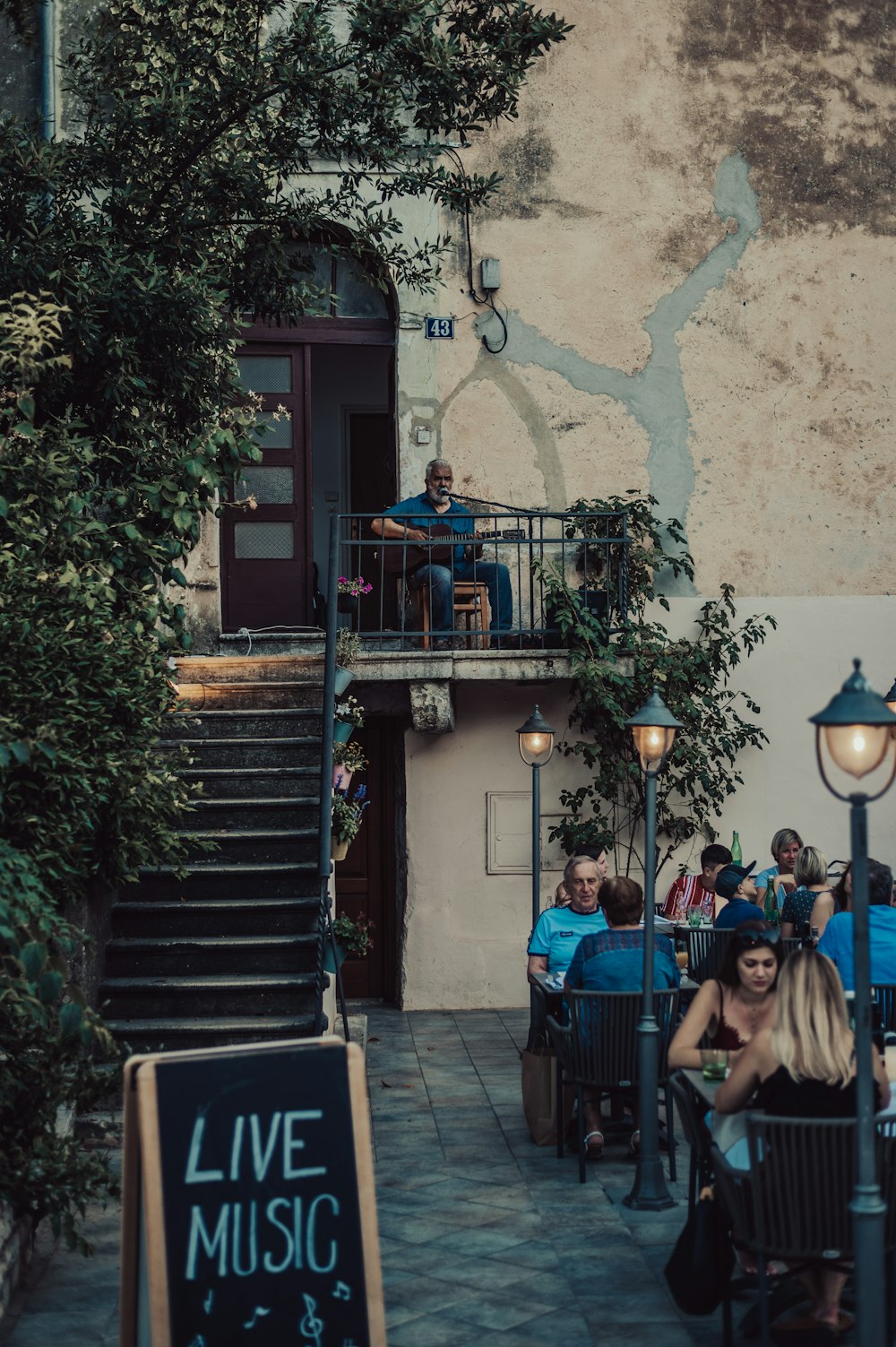 a group of people sitting at tables in front of a building