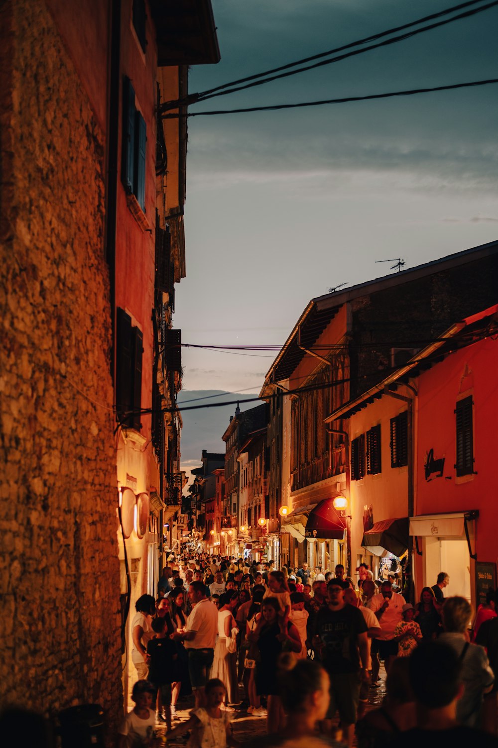 a crowd of people walking down a street next to tall buildings