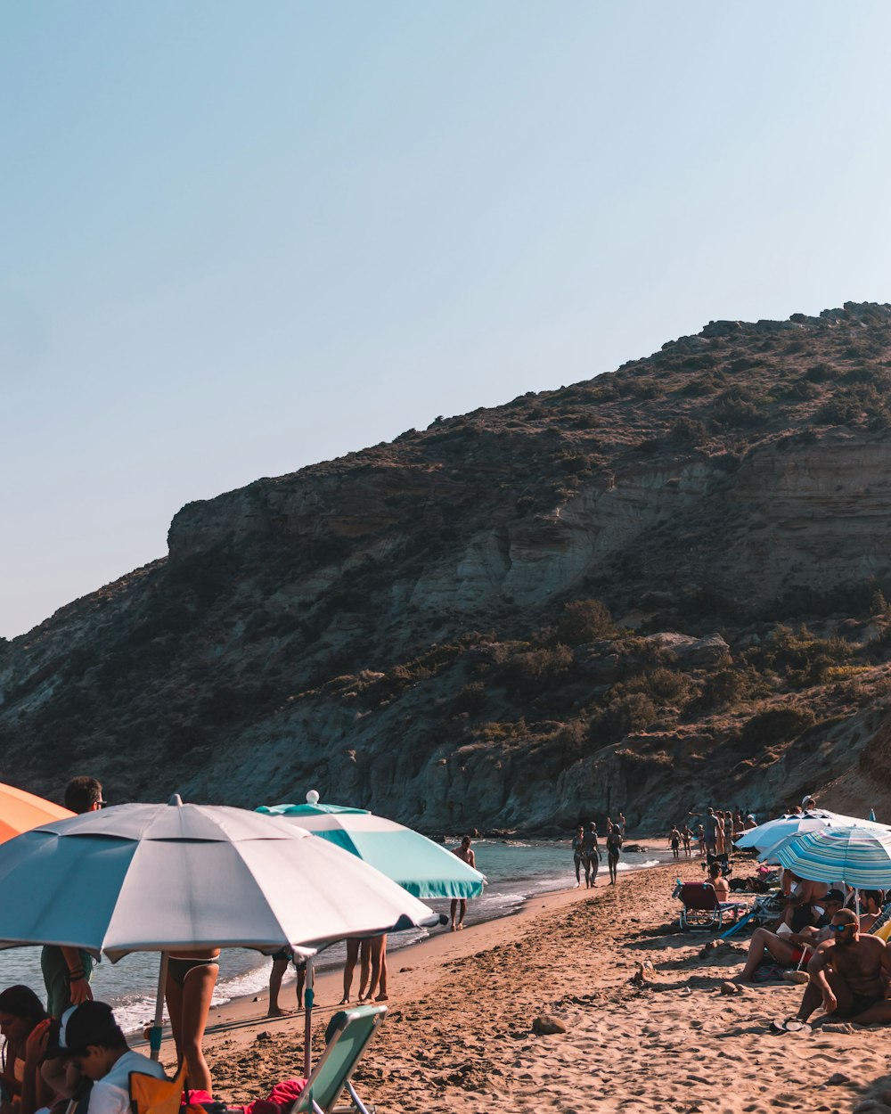 a group of people sitting on top of a sandy beach