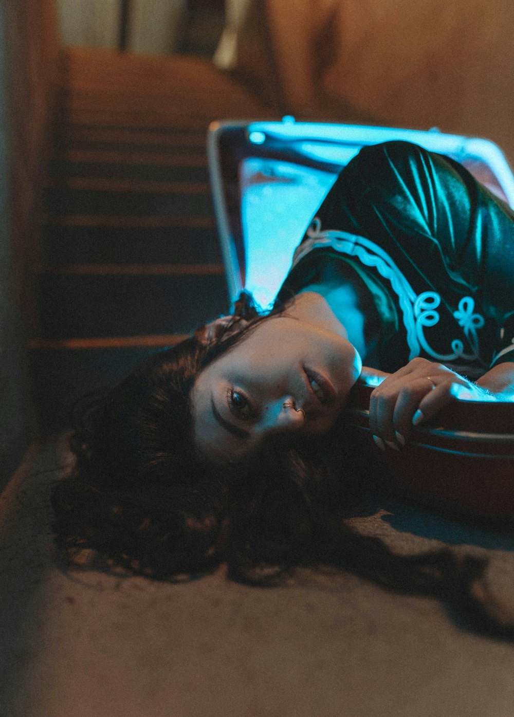 a woman laying on the ground next to a suitcase