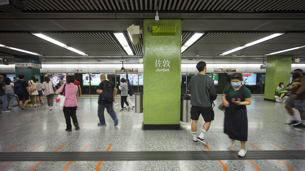 a group of people standing around a subway station