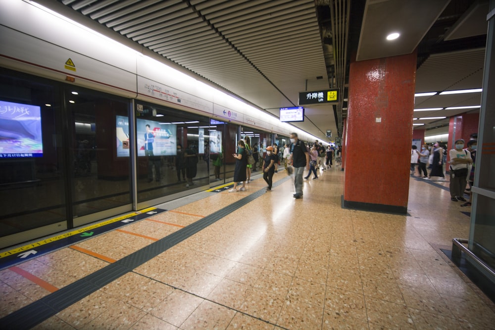 a group of people walking through a train station