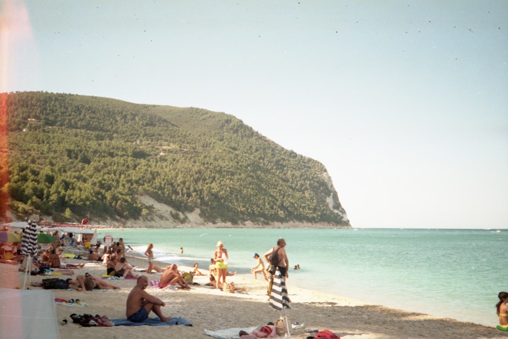 a group of people sitting on top of a sandy beach